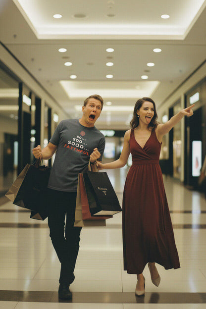A man wearing a grey 'So... Sooo... Faithful' t-shirt looks terrified as his partner pulls him through a shopping mall.